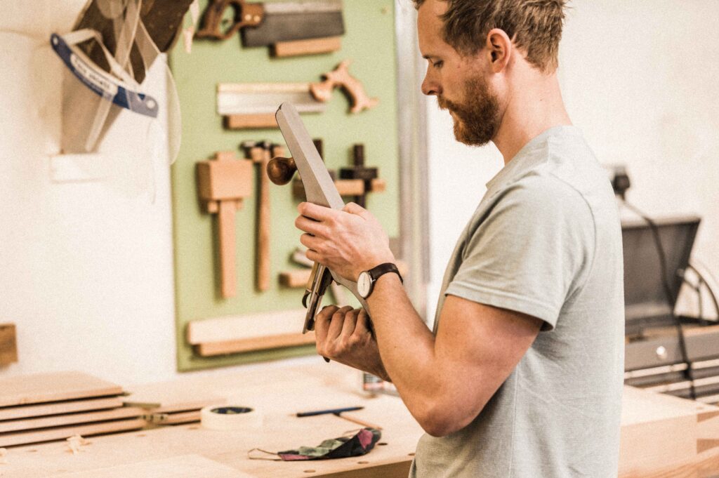 A STUDENT AT ROWDEN ON A FINE FURNITURE MAKING COURSE, WORKING ON FURNITURE COMPONENTS