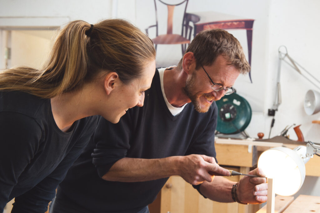 Rowden tutor showing a student how to use a chisel in the hand tool projects at Rowden Atelier