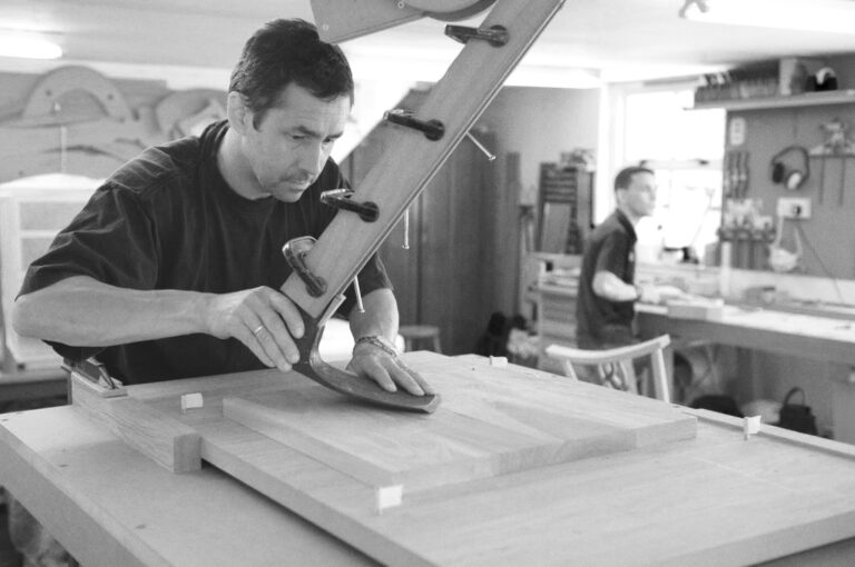 a student using an adze jig to sculpt a seat on a fine furniture making course at Rowden Atelier