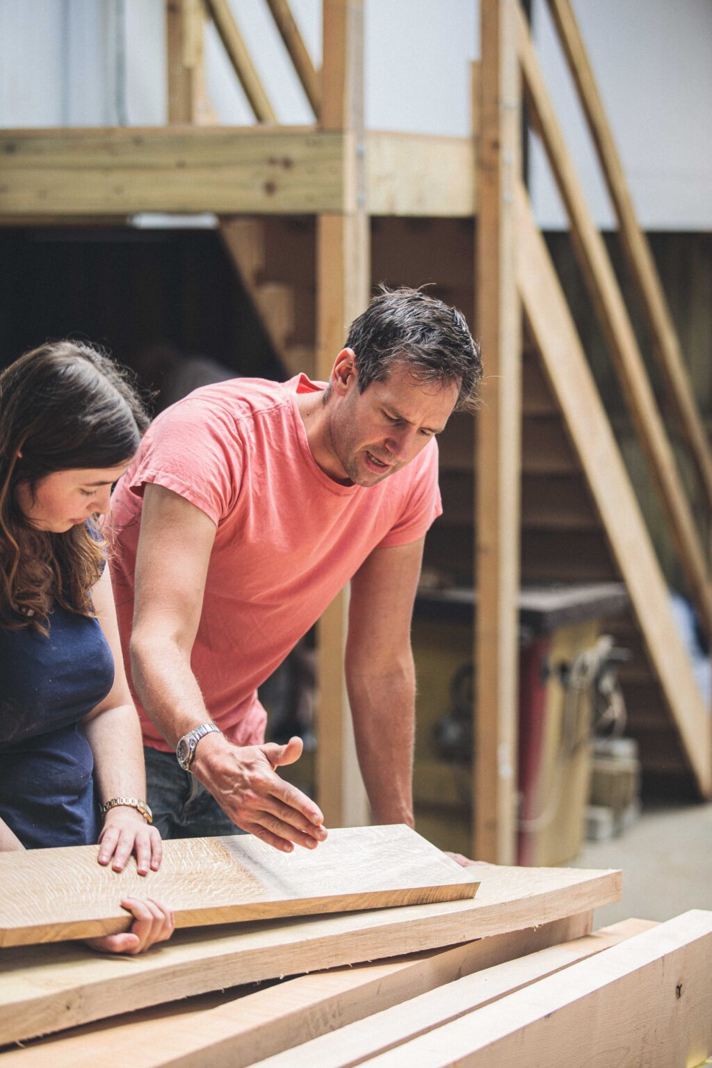 Rowden tutor Ed Wild helping a student in selecting wood for a piece of furniture.