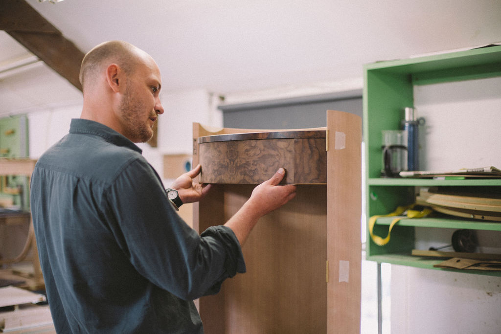 A student fitting a drawer. The drawer is piston fit and has been dovetailed, as part of a fine furniture making course at Rowden Atelier, UK